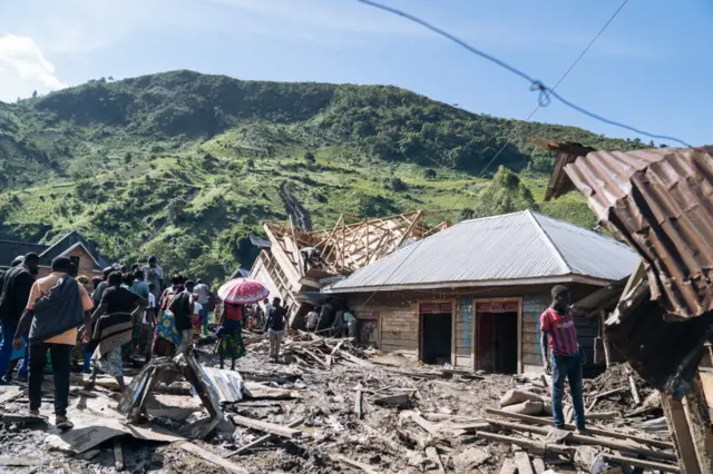 Residents of Nyamukubi stand amidst rubble after heavy flooding in eastern Democratic Republic of Congo, on May 6, 2023.