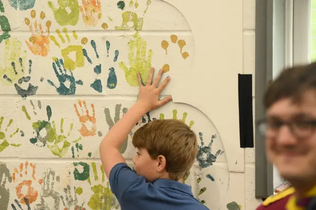 Prince George uses his hand to make paint decorations