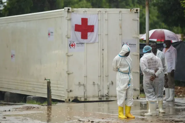 Kenyan government officials and pathologists wearing protective clothing stand by before the start of postmortem analysis on victims of the Shakahola massacre at the Malindi district funeral home, in Malindi on May 1, 2023.