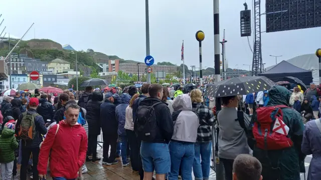 Islanders under umbrellas at Liberation Square