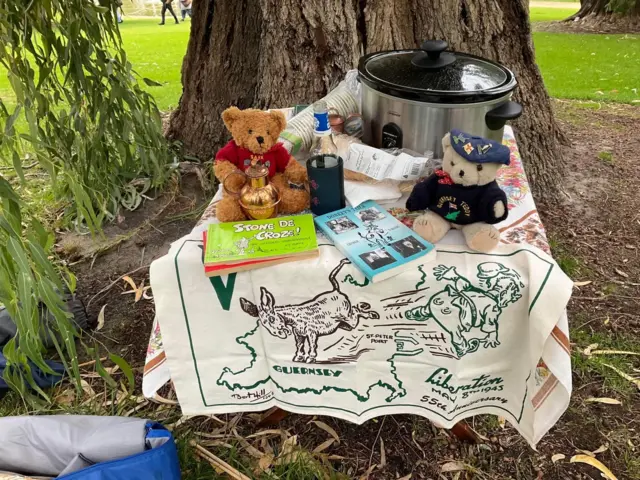 Books, teddies, food and tea towels on a table