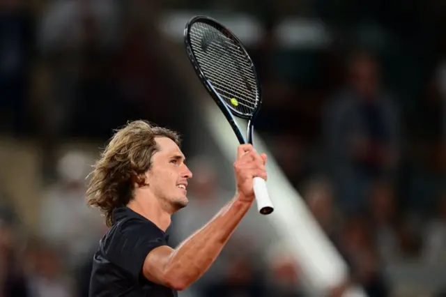 Alexander Zverev holds his racquet to the crowd in celebration