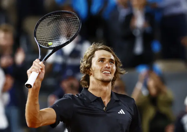 Alexander Zverev smiles and waves racquet to the crowd