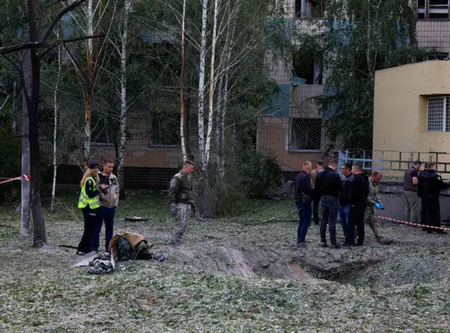 Law enforcement officers stand near a crater formed during a Russian missile strike, at the compound of a municipal clinic, amid Russia’s attack on Ukraine, in Kyiv, Ukraine June 1, 2023