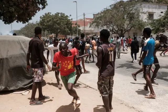 Supporters of opposition leader, Ousmane Sonko run from tear gas fired by police in Dakar on June 1, 2023