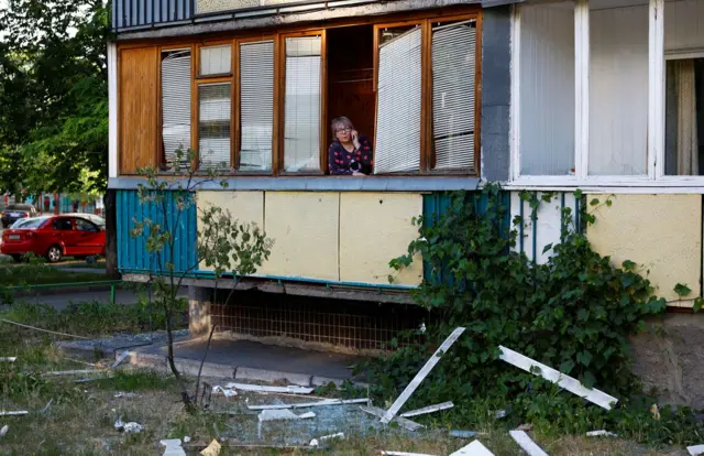 A woman speaks on her mobile phone at a balcony of her apartment damaged during a Russian missile strike, amid Russia's attack on Ukraine, in Kyiv, Ukraine June 1, 2023