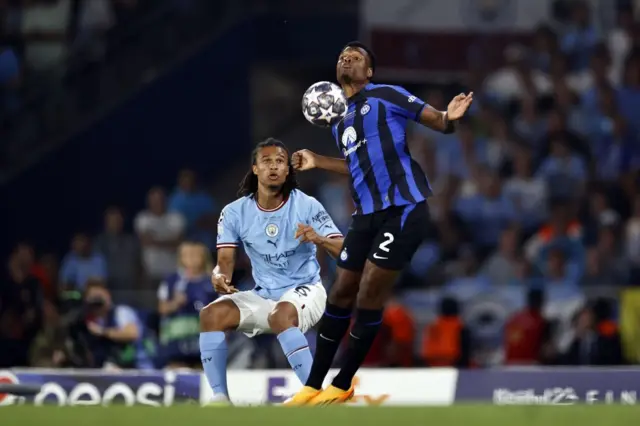 Denzel Dumfries chests the ball as Nathan Ake watches on