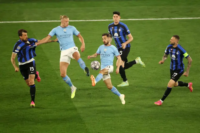 Bernardo Silva controls the ball in the middle of a group of players