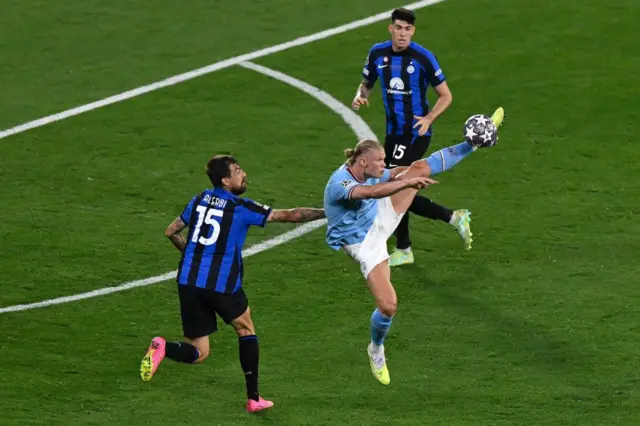 Erling Haaland reaches up his leg to reach the ball