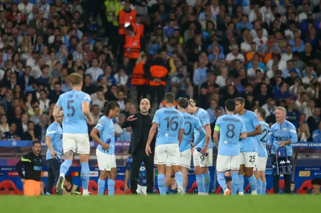 Pep Guardiola in the middle of his Man City players