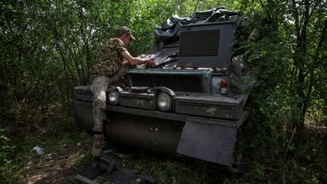 A Ukrainian serviceman repairs an armoured vehicle