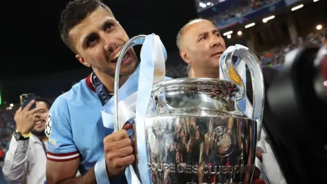 Rodri holds the Champions League trophy