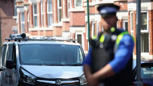 A police officer guards the van