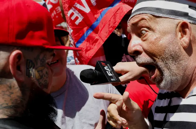 An anti-Trump protester faces off with a Trump supporter outside the courthouse