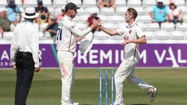 Essex skipper Tom Westley congratulates Jamie Porter on taking the wicket of Sean Dickson