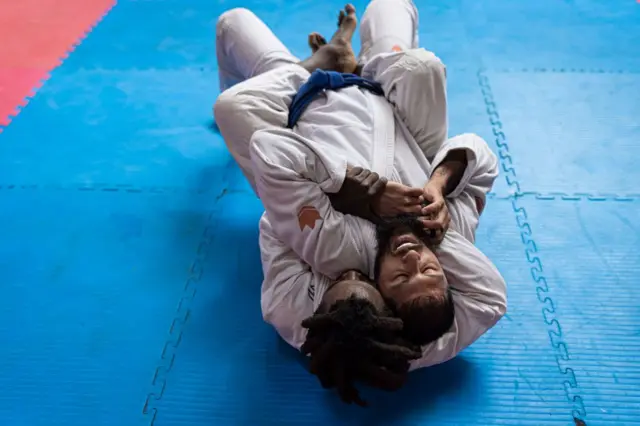 Two people competing in a Brazilian Jiu-Jitsu competition