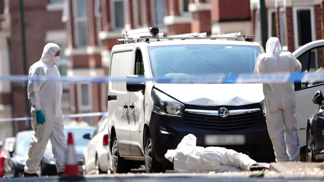 Police forensics officers search a white van on the corner of Maples Street and Bentinck Road in Nottingham