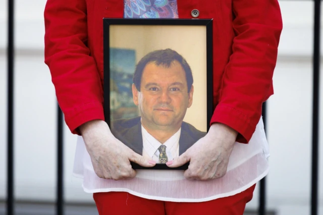 A close-up of one photograph being held by a campaigner