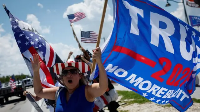 A supporter of the former president brandishes a Trump 2024 flag