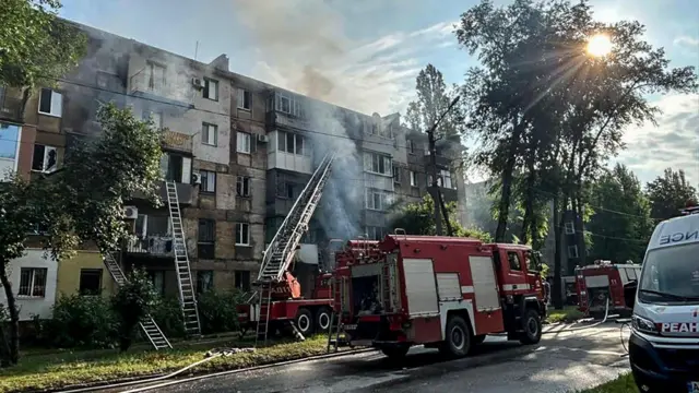 A fire engine working at the site of a damaged residential building in Kryvyi Rih