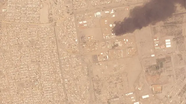 Satellite image from Planet Labs showing fire still burning at the Al-Shajra fuel depot on Monday