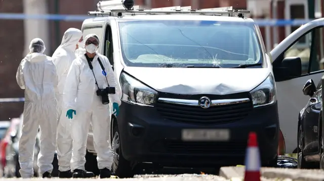 Forensics officers investigate a white Vaxuhall Vivaro van, left near the scene of the attacker's arrest