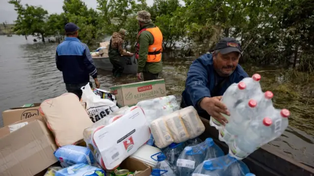 Volunteers deliver humanitarian aid to local residents in the village of Afanasiivka following the dam breach