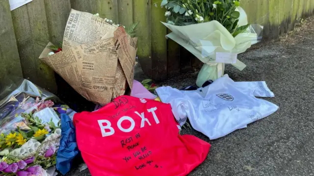 Ian Coates' sons left football shirts beside floral tributes at the scene where he was killed in Nottingham