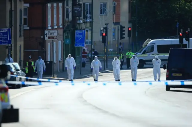 Police forensic officers search the area in Ilkeston Road in Nottingham