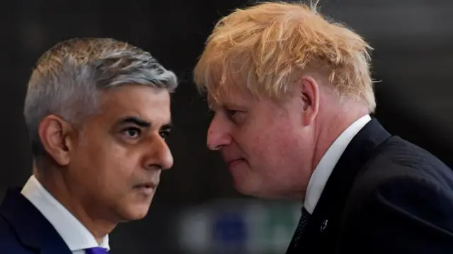 British Prime Minister Boris Johnson and mayor of London Sadiq Khan pass each other during an engagement to mark the completion of the Elizabeth Line at Paddington Station in London, Britain, May 17, 2022