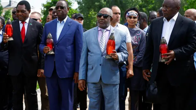 African leaders holding lanterns at a site of a mass grave in the town of Bucha outside of Kyiv, Ukraine - 16 June 2023