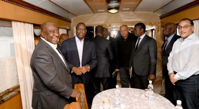 African delegation stand in train carraige