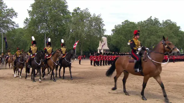 Mounted troops ride past King