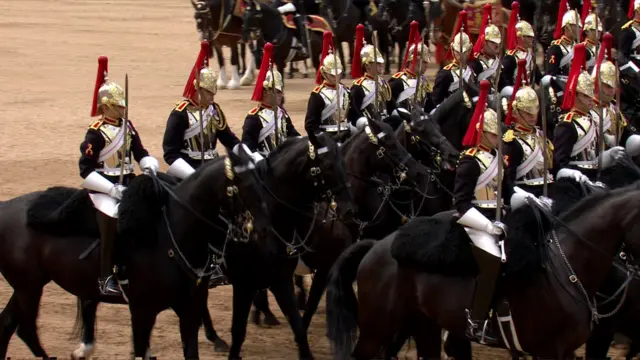 Mounted troops riding past the King