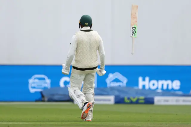 Usman Khawaja throwing his bat into the air to celebrate his century