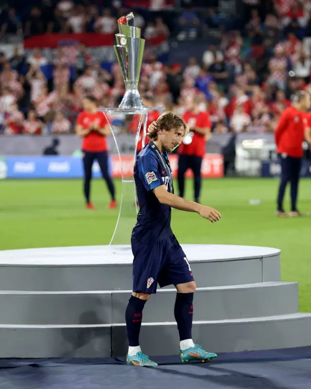 Luka Modric walks past Nations League trophy