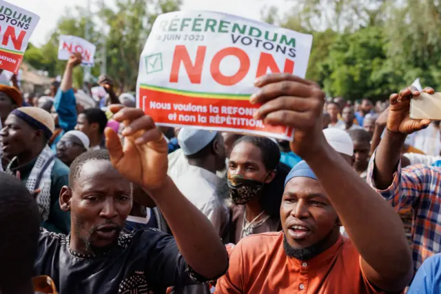 A man holds up a sign that reads "vote no in the referendum" during a march against the new constitution organised by the Association of Imams, in Bamako - 16 June 2023