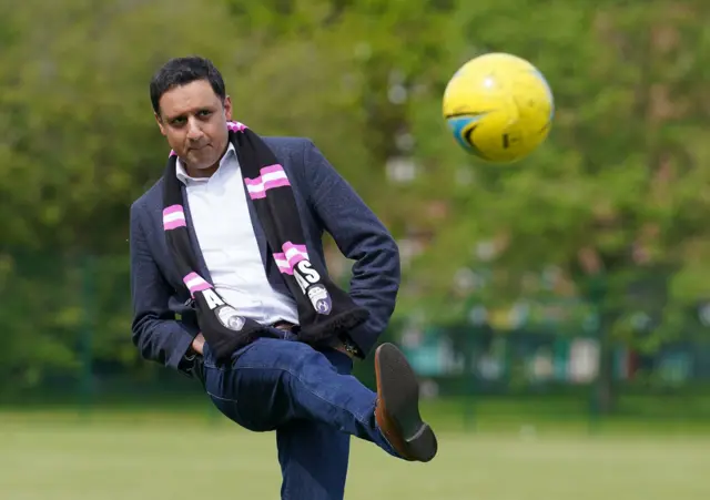 Anas Sarwar kicks a ball during a photo opportunity in Glasgow