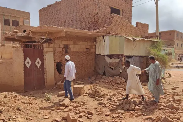 People check a damaged house in southern khartoum on June 12, 2023