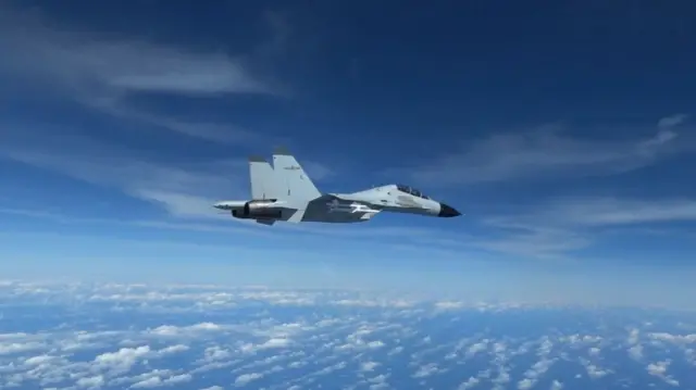 A Chinese Navy J-11 fighter jet flies close to a US Air Force RC-135 aircraft over the South China Sea