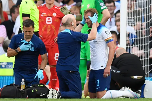 Harry Kane gets checked by the physio during England's Euro 2024 qualifier against North Macedonia at Old Trafford