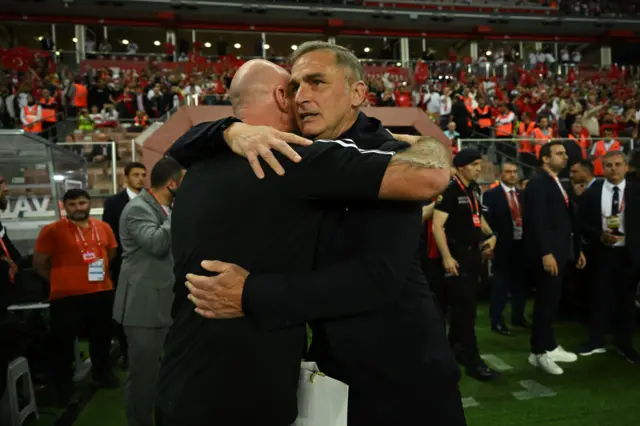 Rob Page, Head Coach of Wales, and Stefan Kuntz, Head Coach of Turkey, embrace