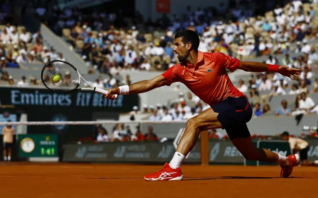 Novak Djokovic stretches to hit the ball with his racquet
