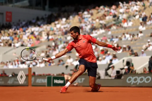 Novak Djokovic slides to hit the ball
