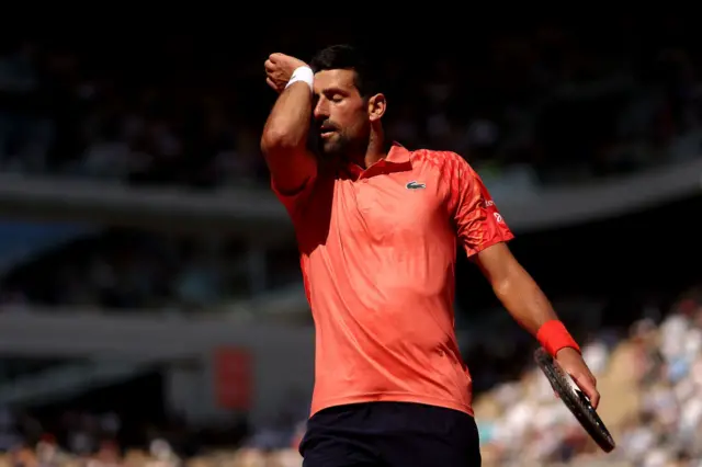 Novak Djokovic wipes his forehand with his wrist sweatband