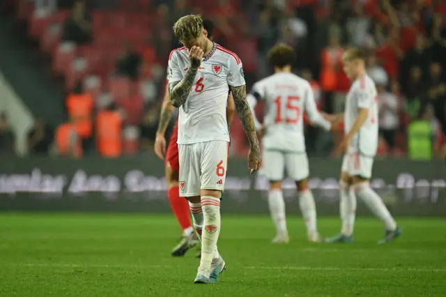 Joe Rodon holds his head in his hands after Wales lose at Turkey