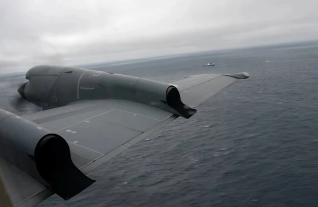 A Royal Canadian Air Force CP-140 Aurora maritime surveillance aircraft of 14 Wing flies a search pattern for the missing OceanGate submersible