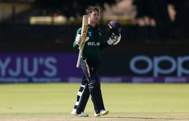 Curtis Campher raises his bat after reaching three figures