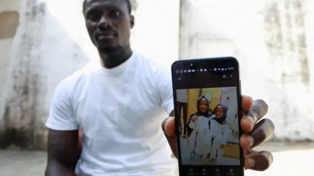 Ebrima Saidy shows a picture on his phone of his twin daughters, one of whom died of acute kidney injury in September 2022 -  Tanji, Gambia