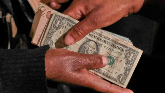 Someone handing over money - US dollars - in Harare, Zimbabwe - February 2023